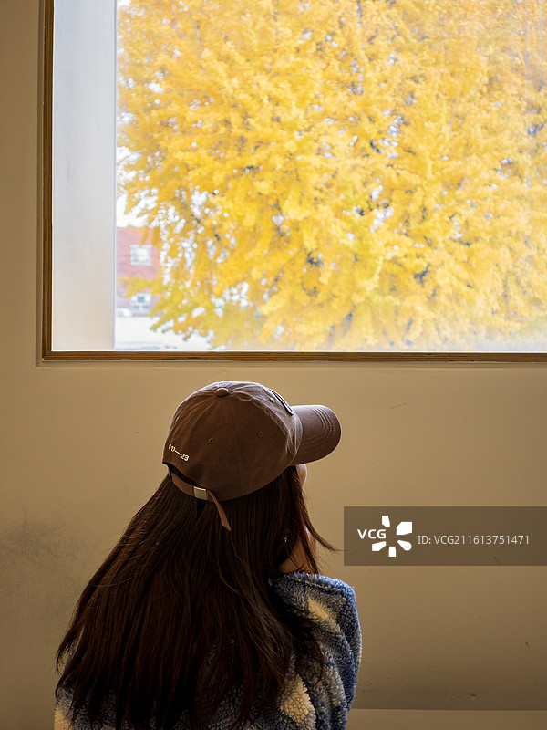 女游客在室内窗口通过框景欣赏景福宫秋色图片素材