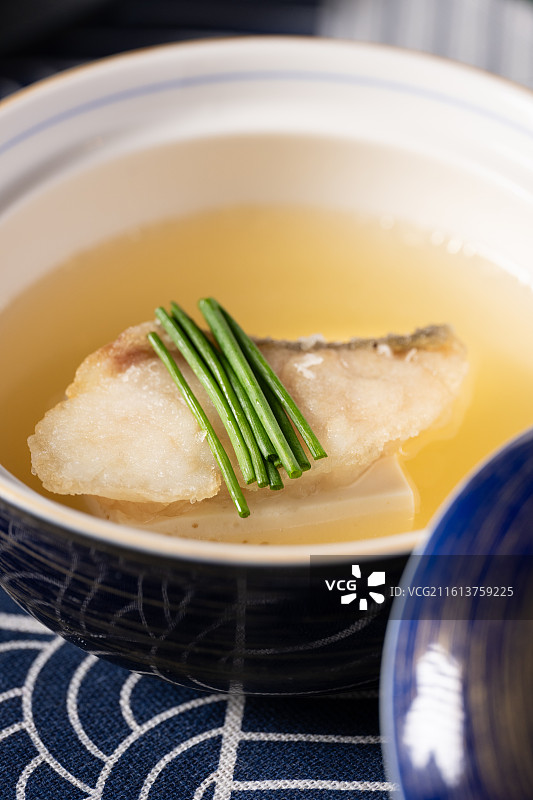 传统日式海鲜清汤，包含酥炸鱼排、嫩豆腐和新鲜青葱。图片素材
