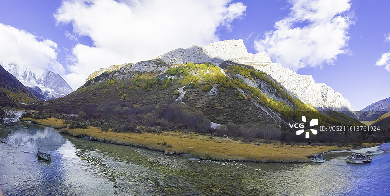 稻城亚丁十六尊者：亚丁三怙主神山绝壁上，有一组神似十六尊石像的岩石，由山岩自然分化而成，彩林，碧水图片素材