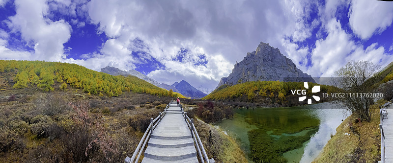 稻城亚丁十六尊者：亚丁三怙主神山绝壁上，有一组神似十六尊石像的岩石，由山岩自然分化而成，彩林，碧水图片素材