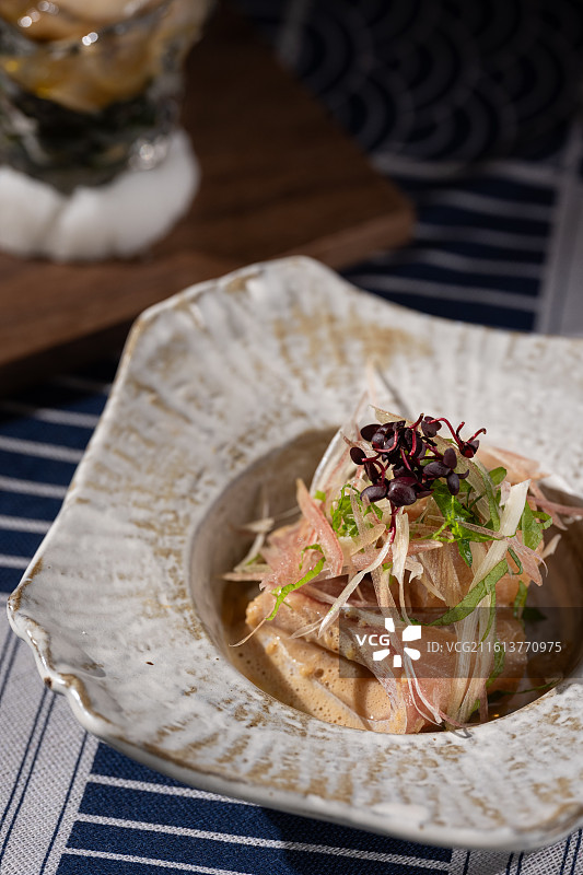 瓷碗中搭配胡麻酱的油甘鱼刺身前菜，点缀以新鲜茗荷与大叶。图片素材