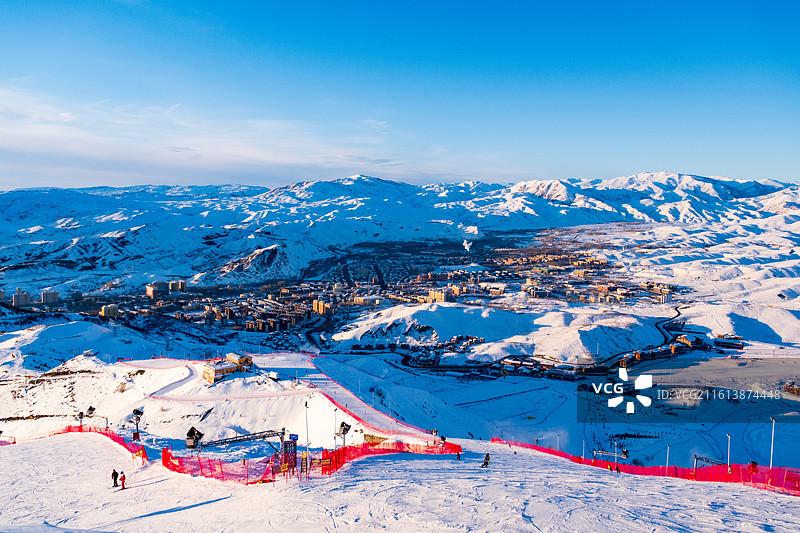冬天新疆阿勒泰将军山滑雪场俯瞰冬季雪后雪山与城市景观的高角度俯瞰图图片素材