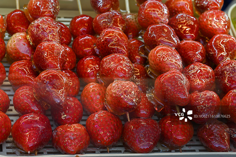 晶莹剔透的冰糖草莓串，冬日街头的甜蜜诱惑图片素材