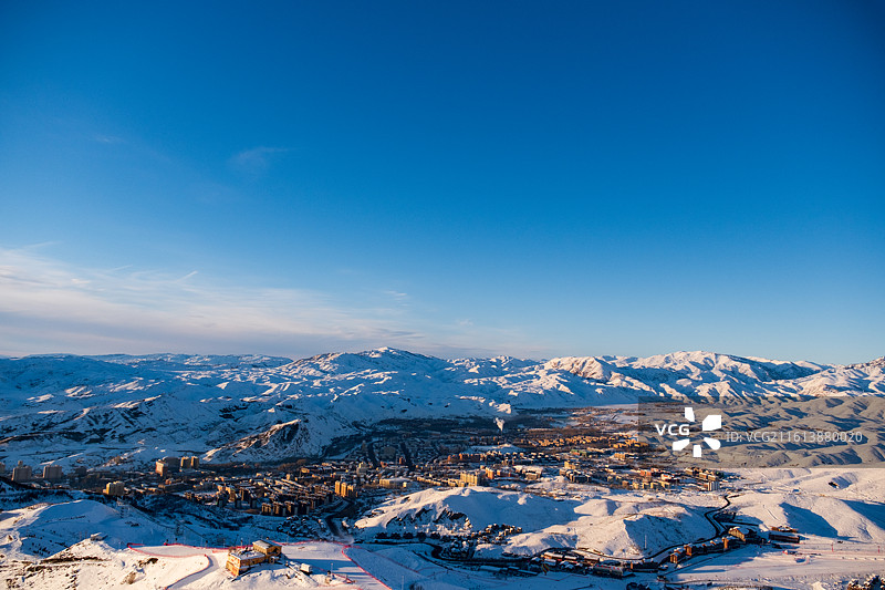 冬天新疆阿勒泰将军山滑雪场俯瞰冬季雪后雪山与城市景观的高角度俯瞰图图片素材