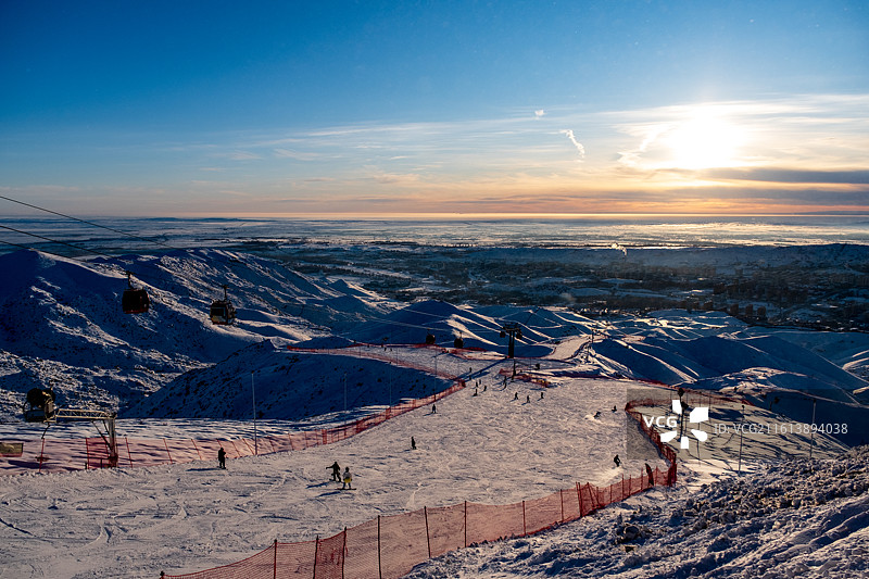 冬天新疆阿勒泰将军山滑雪场俯瞰冬季雪后雪山与城市景观的高角度俯瞰图，日落时白雪皑皑的群山景色图片素材
