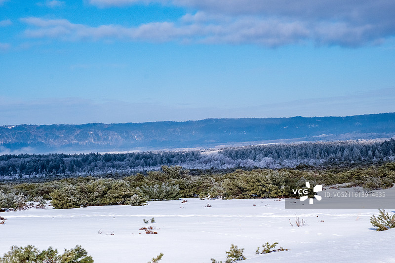 冬天日本北海道道东钏路市阿寒摩周国立公园，白雪皑皑的群山映衬着多云的天空图片素材