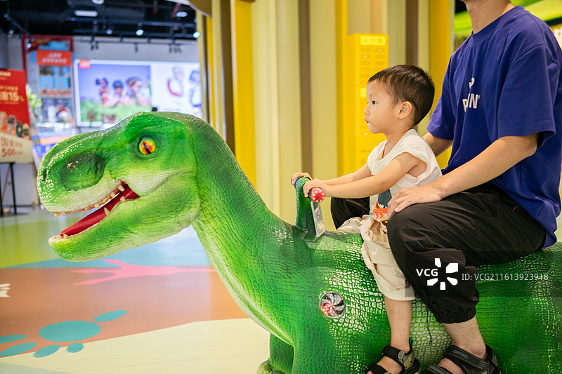 和爸爸在广州正佳广场开恐龙车的小男孩图片素材