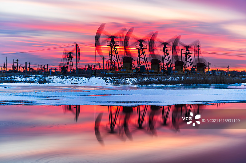 冬天的大庆油田，湖面未完全结冰，在落日霞光的映照下，工作中的抽油机划出完美的弧线。图片素材