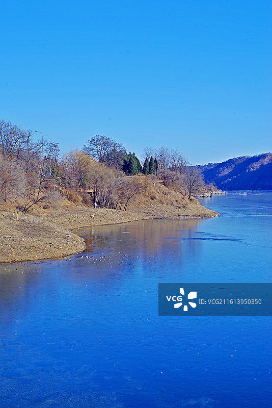 《湖天一色》大连西山湖公园   寒冬季节，湖面已结薄冰，在蓝天映照下反射着蓝光图片素材