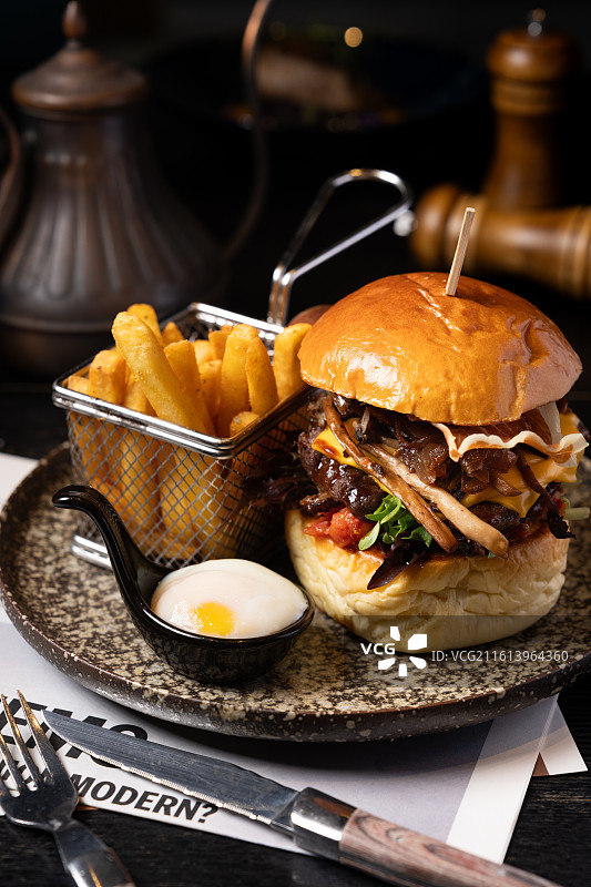 精品美国牛腱肉汉堡配融化芝士与帕尔玛火腿，附带酥脆薯条及一份温泉蛋。图片素材