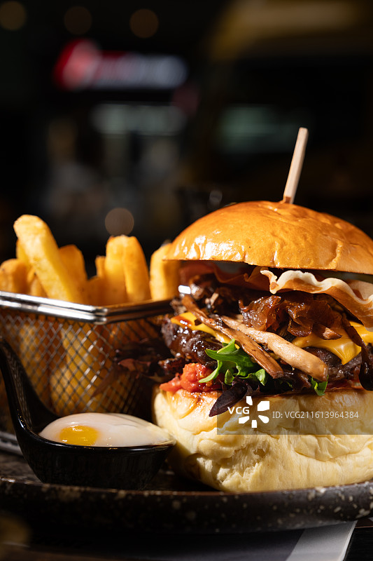 精品美国牛腱肉汉堡配融化芝士与帕尔玛火腿，附带酥脆薯条及一份温泉蛋。图片素材