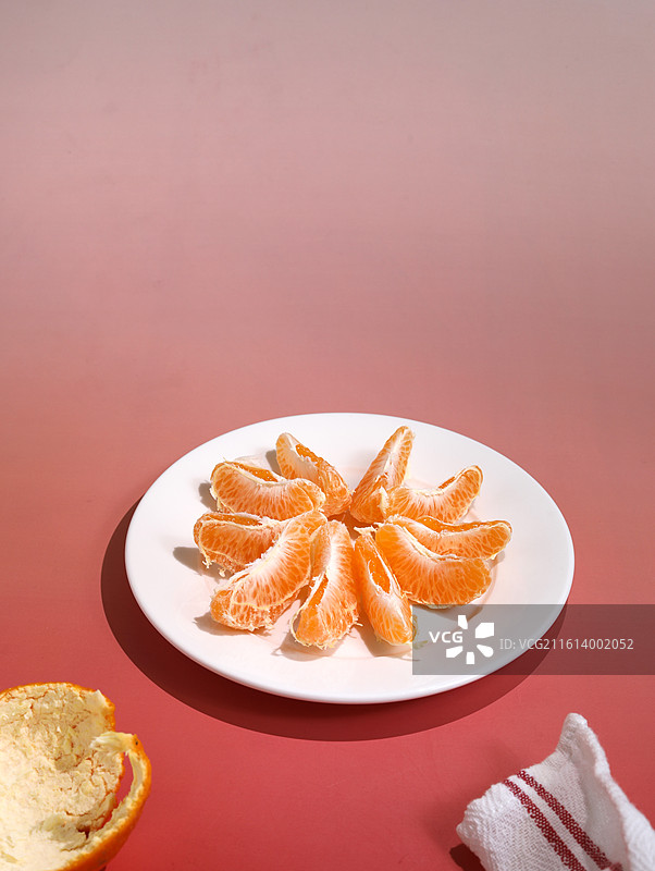 红色桌面上摆放着中国春节年货美食新鲜剥开的橘子果肉图片素材