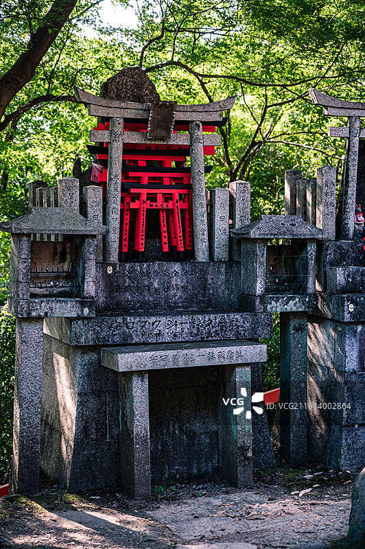伏见稻荷大社内的石质神龛与供奉的鸟居图片素材