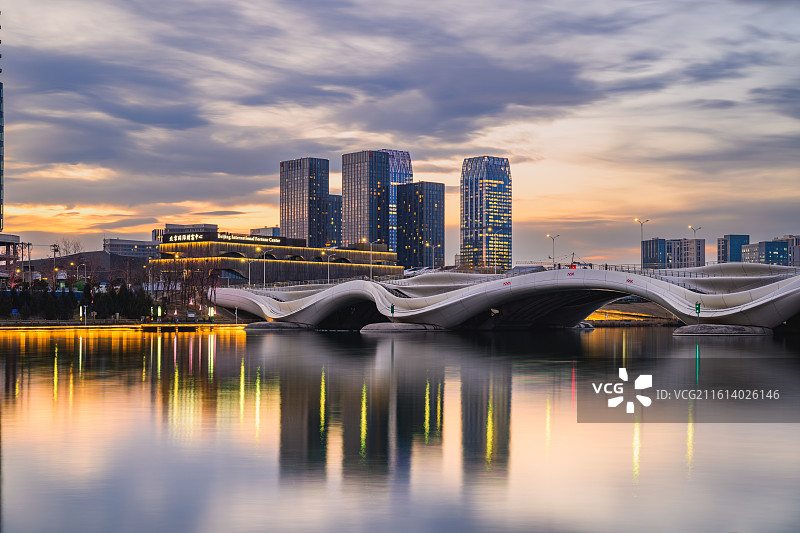 北京通州（北京城市副中心），京杭大运河，千荷泻露桥，运河商务区天际线（新光大中心）；晚霞、多云天气。图片素材