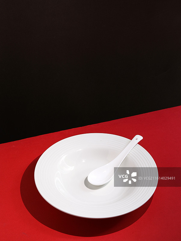 红色桌面上摆放着白色的餐具瓷器碗盘子碟子图片素材