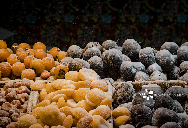 东北雪中的冻梨与冻柿子，雪中的冰冻的水果，东北冬天特色水果图片素材