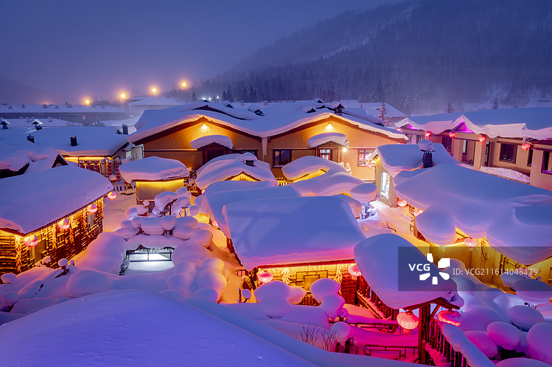 中国雪乡童话世界的夜景，灯火通明的乡村，冬天的雪乡热闹的场面，熙熙攘攘的人群图片素材