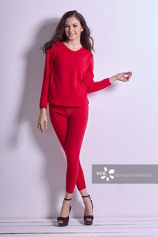 白色背景下的年轻女子红色衣服全身图片素材