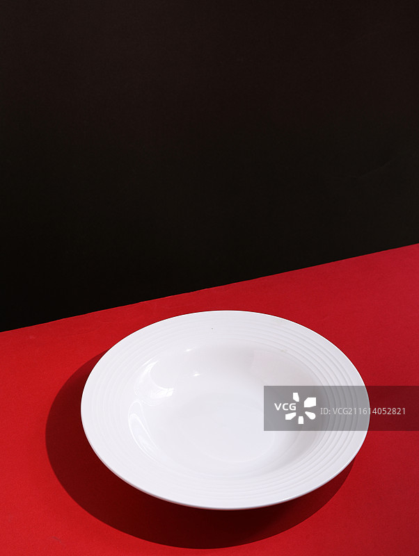 红色桌面上摆放着装美食的空盘子背景图图片素材