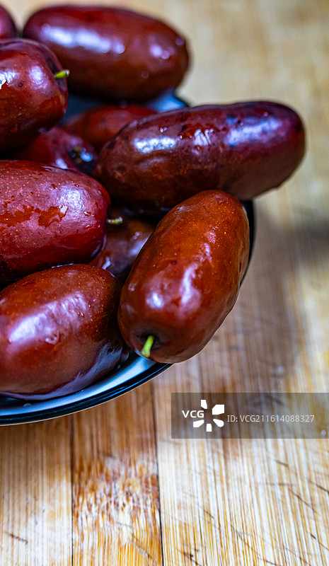 木桌上碗里的宁夏灵武长红枣枣子特写镜头.宁夏灵武长红枣与新疆和田大枣的区别图片素材