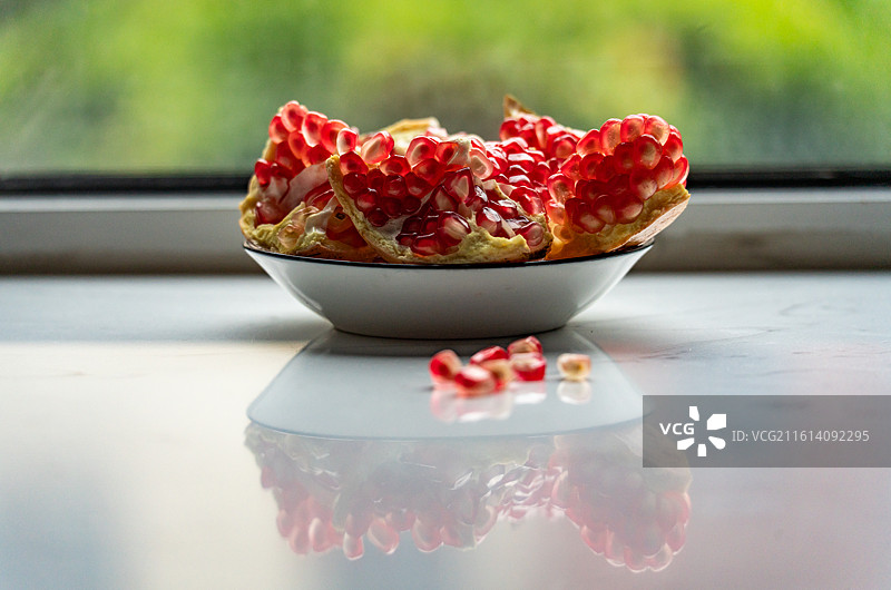 盘子里的新鲜石榴红石榴石榴籽水果食物的高角度视图图片素材