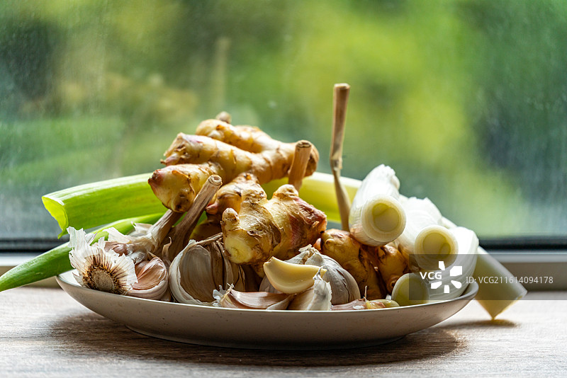 绿色虚化背景中盘子里的新鲜葱山东大葱章丘大葱葱白调味品食物的高角度视图图片素材