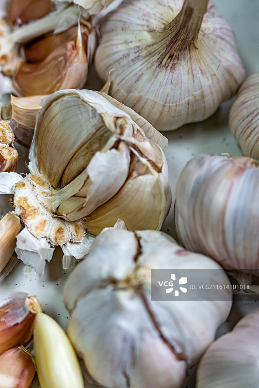 木桌上盘子里的新鲜大蒜蒜头紫皮蒜调味品食物的高角度视图.金乡大蒜苍山大蒜的区别图片素材
