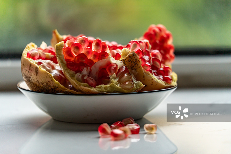 盘子里的新鲜石榴红石榴石榴籽水果食物的高角度视图图片素材
