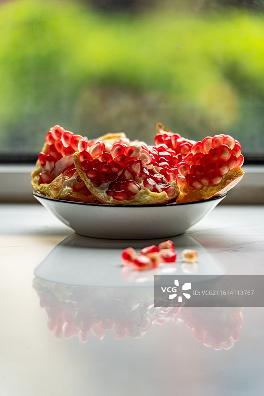 盘子里的新鲜石榴红石榴石榴籽水果食物的高角度视图图片素材