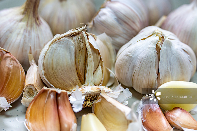 木桌上盘子里的新鲜大蒜蒜头紫皮蒜调味品食物的高角度视图.金乡大蒜苍山大蒜的区别图片素材