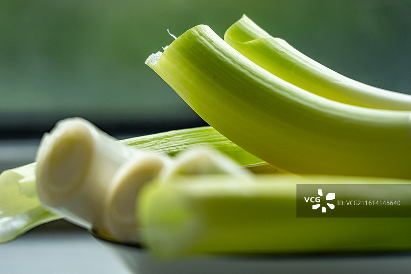 绿色虚化背景中盘子里的新鲜葱山东大葱章丘大葱葱白调味品食物的高角度视图图片素材