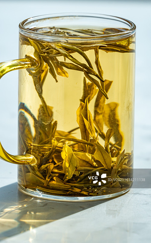 绿色虚化背景中窗户阳台上的茶杯茶具一杯清茶特写镜头图片素材