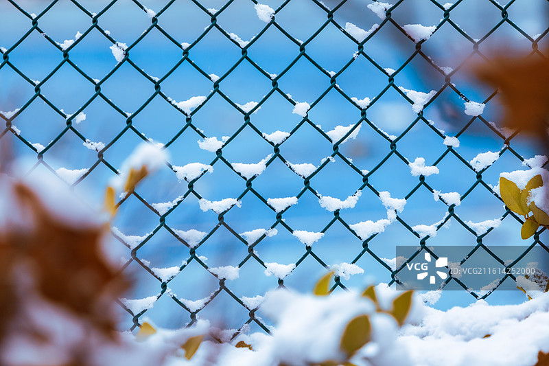 公园球场的铁丝网围栏下雪后积攒的白雪天气寒冷空气清新蓝色背景图片素材