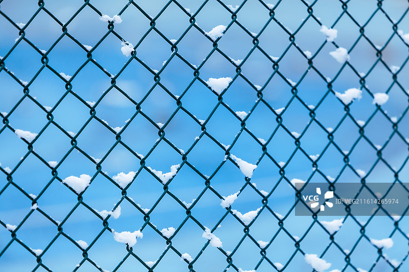 公园球场的铁丝网围栏下雪后积攒的白雪天气寒冷空气清新蓝色背景图片素材