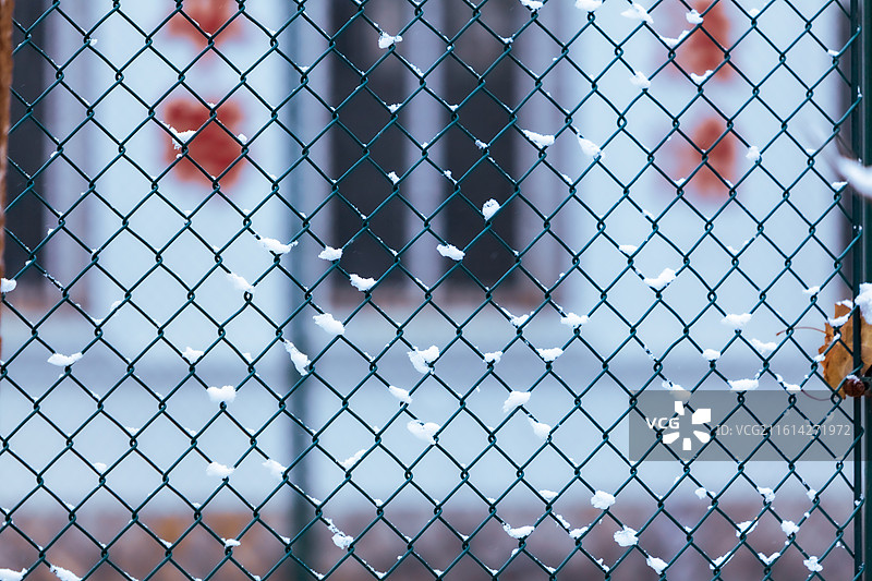公园球场的铁丝网围栏下雪后积攒的白雪天气寒冷空气清新蓝色背景图片素材
