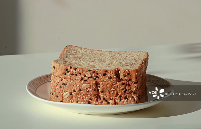 阳光下盘子里的全麦面包图片素材