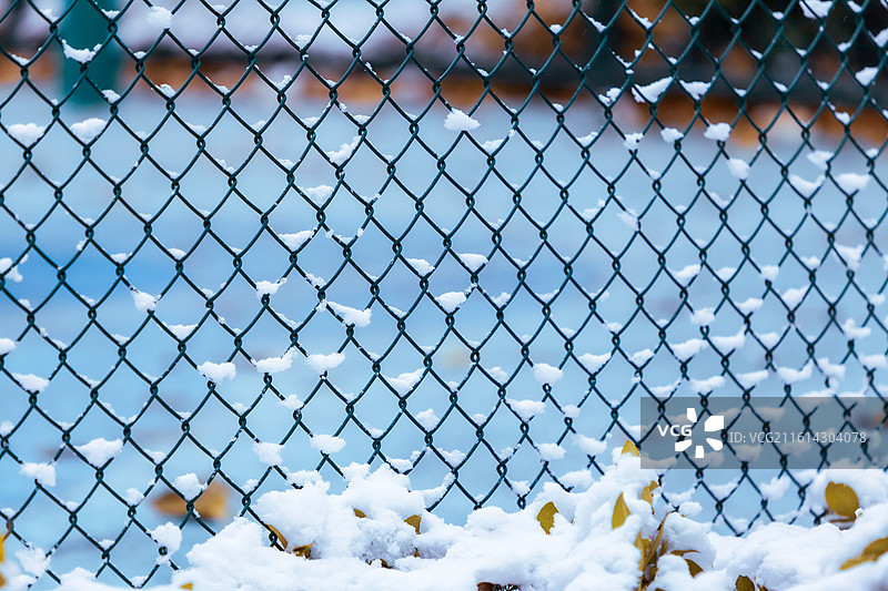 公园球场的铁丝网围栏下雪后积攒的白雪天气寒冷空气清新蓝色背景图片素材