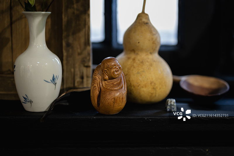 桌上花瓶和弥勒佛木雕特写镜头图片素材