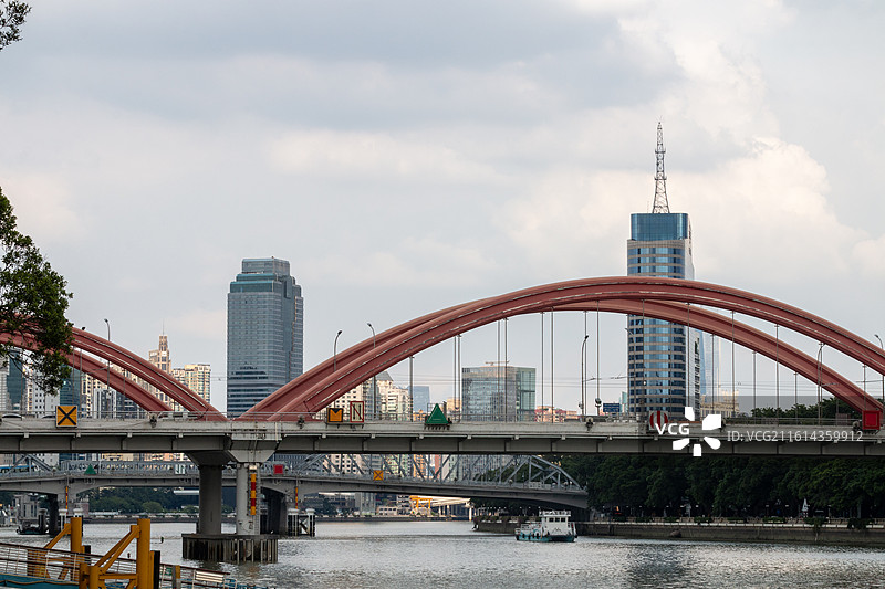 秋天蓝天白云下的广州红色解放桥和城市摩天大楼建筑自然风光图片素材