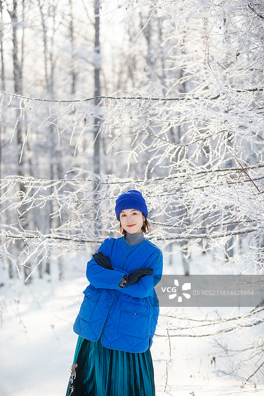 冬季阿尔山森林公园里的雾凇里开心微笑的美女图片素材