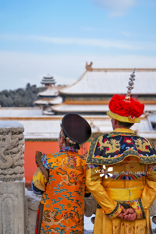 冬天北京故宫宫殿古建筑雪景与皇上皇后背影图片素材