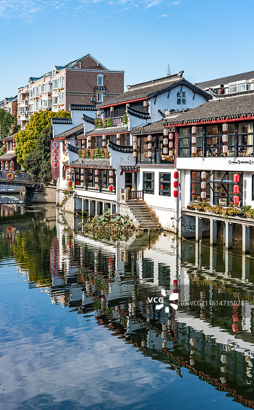 蓝天下的上海闵行七宝老街古镇建筑倒影景观与天空掠过的飞机特写镜头图片素材