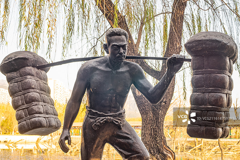 中国山东泰安泰山秀城天平湖公园风景区，挑山工人物形象雕塑地标建筑，户外白昼无人图像摄影图片素材