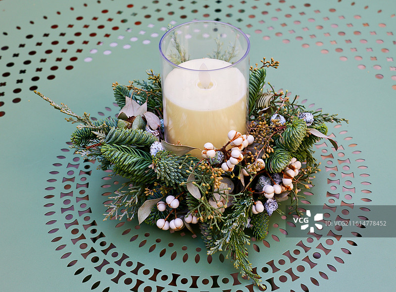 绿色铁艺桌子上的蜡烛和花艺装饰图片素材