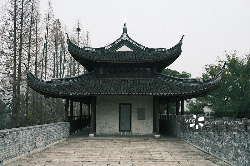 浙江嘉兴古城墙上的传统中式亭台楼阁建筑与冬季枯树景观图片素材