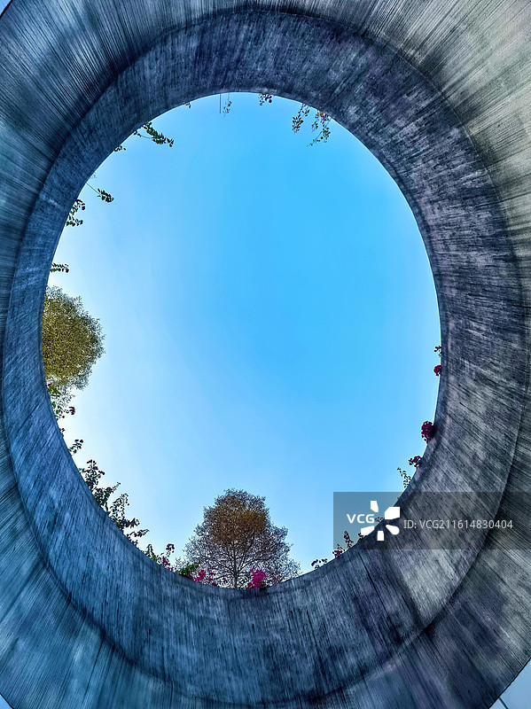 圆形天井·天空之镜 混凝土圆环框住澄澈蓝天，树影与繁花点缀边缘，天地灵气尽收于此一方“天空之镜”。图片素材
