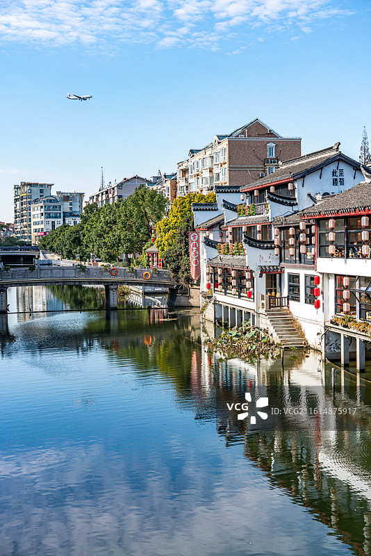 蓝天下的上海闵行七宝老街古镇建筑倒影景观与天空掠过的飞机特写镜头图片素材