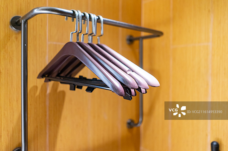 中国生活用品拍摄主题，一个放衣服的黄色的实木衣柜橱柜和三个灰色的挂衣架，室内无人图像摄影图片素材