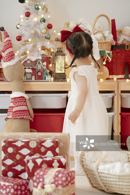 圣诞节里惊喜收到许多圣诞礼物的两岁小女孩图片素材
