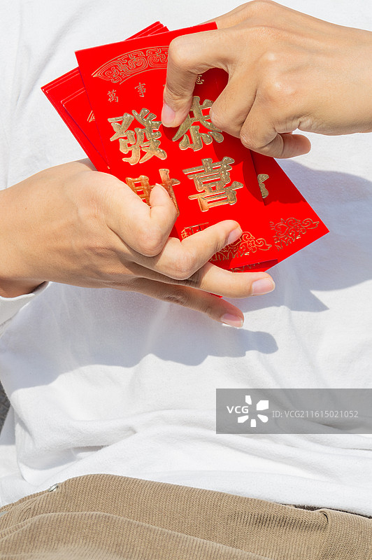 脑瘫患者正面手持“恭喜发财”红包，展示农历新年的美好祝愿与生活态度。图片素材